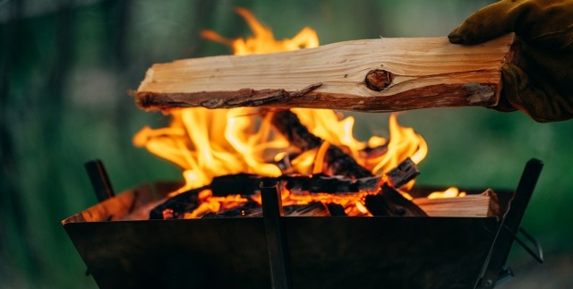 キャンプで薪をくべる焚き火